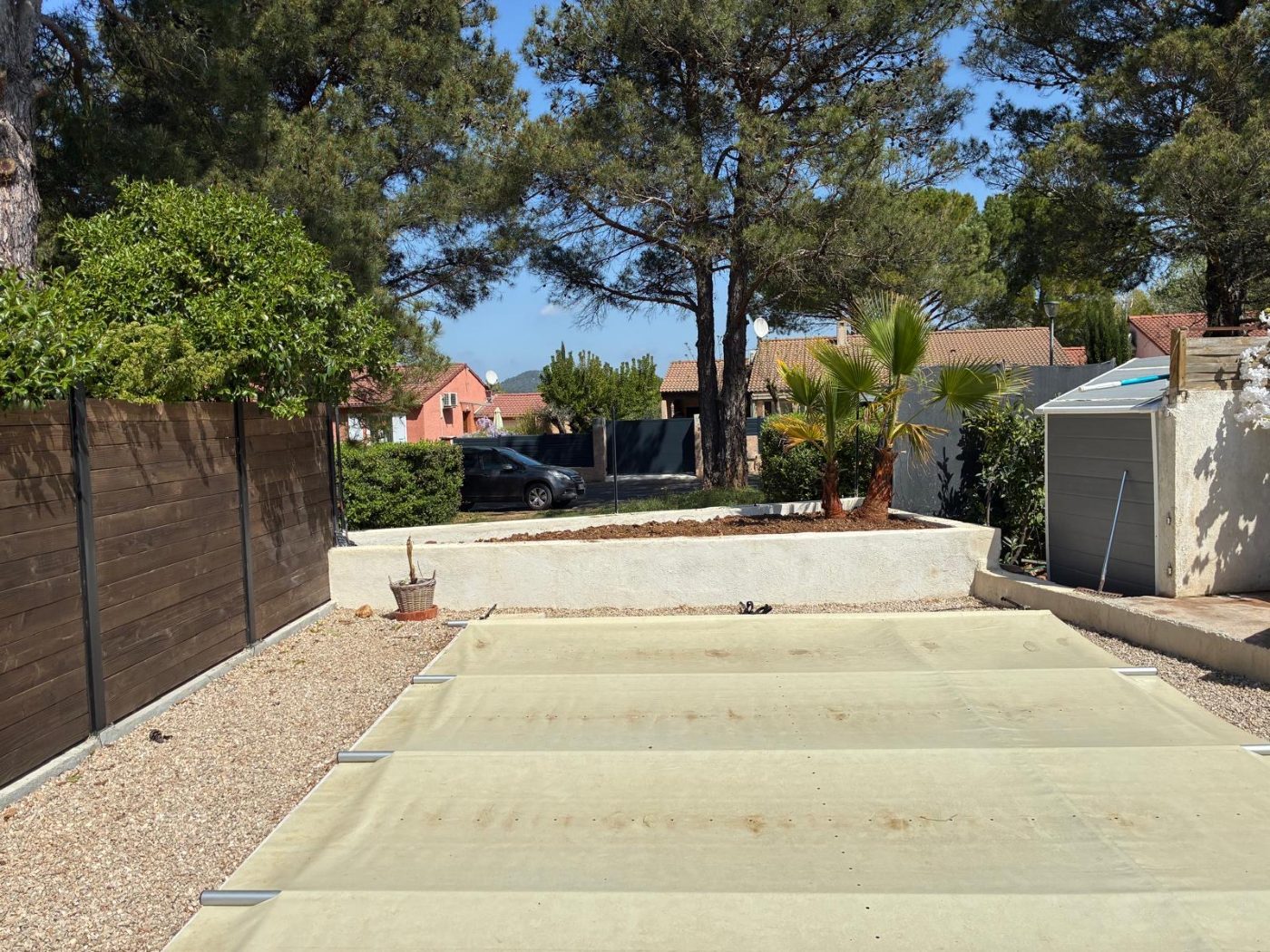 Jardin créé : muret enduit, palmiers, clôture bois et gravier