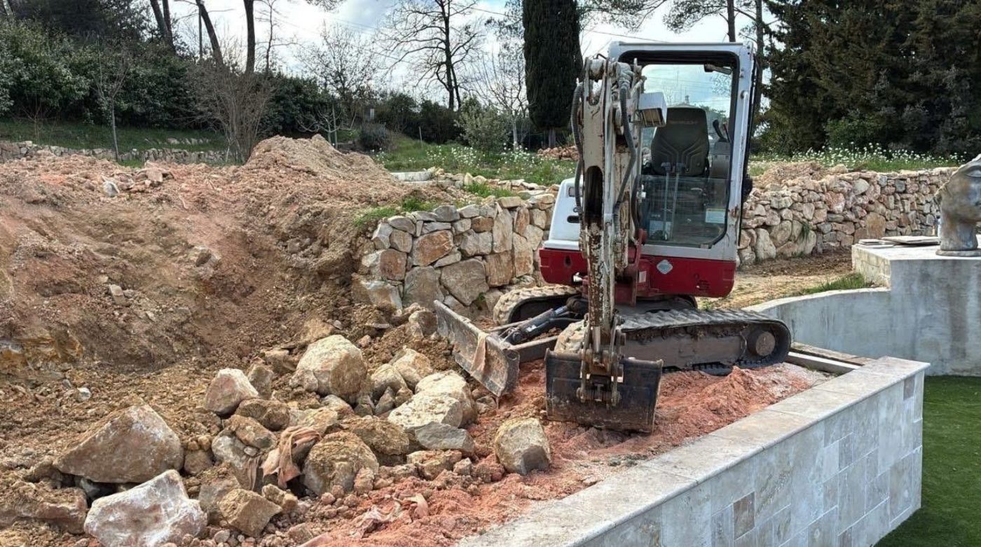 Mini-pelle et blocs de roche lors d’un enrochement
